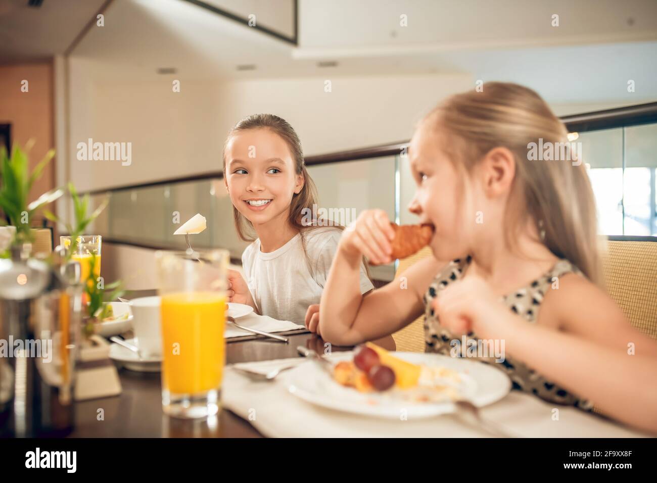 Cute siblings sitting at the table and having breakfast Stock Photo