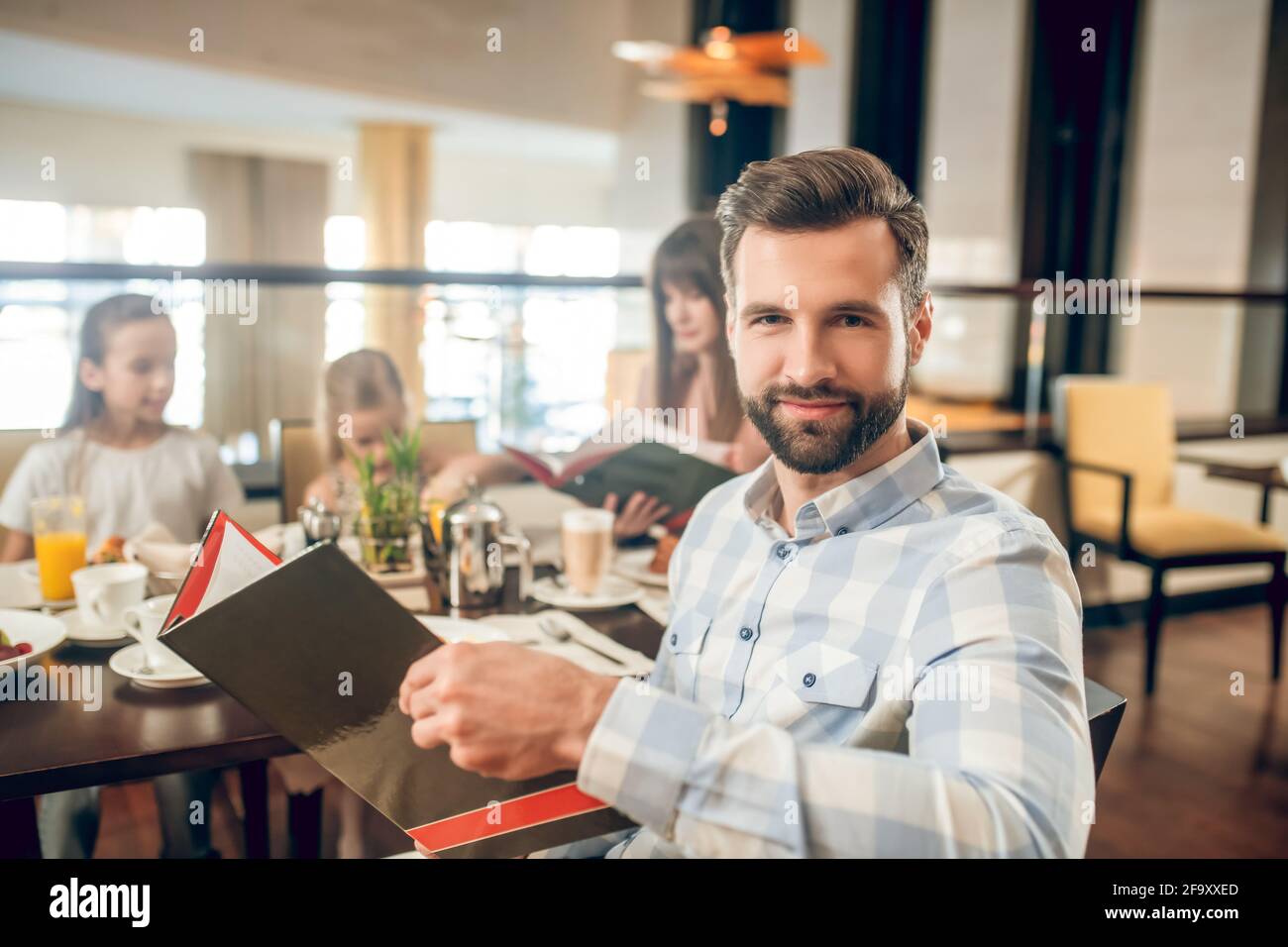 Young man holding a menu and choosing what to order Stock Photo