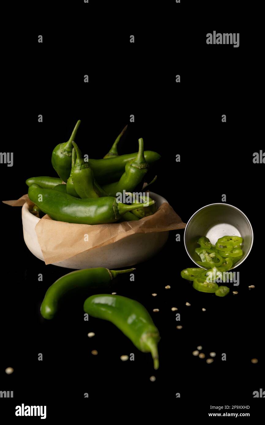 green chili peppers cut into rings in a bowl with parchment. Chili