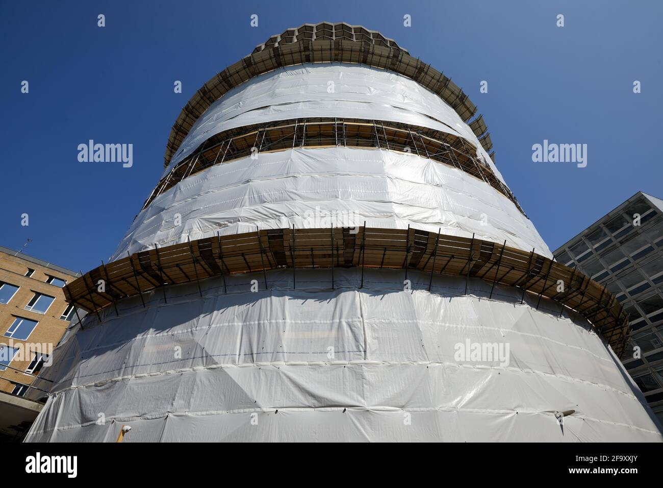 London, UK - 20 Apr 2021:  Space House, a 17-storey cylindrical  office tower in the Holborn area, partially wrapped in protective sheeting. Stock Photo