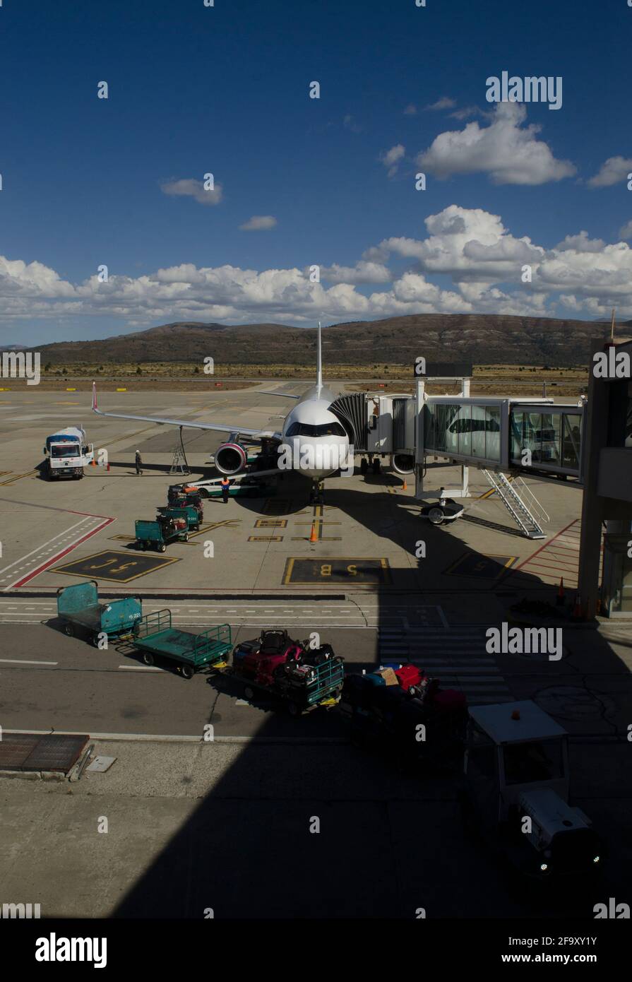 plane with sleeve on, for passenger transport, vertical, and truck  dispatching luggage at bariloche airport Stock Photo - Alamy
