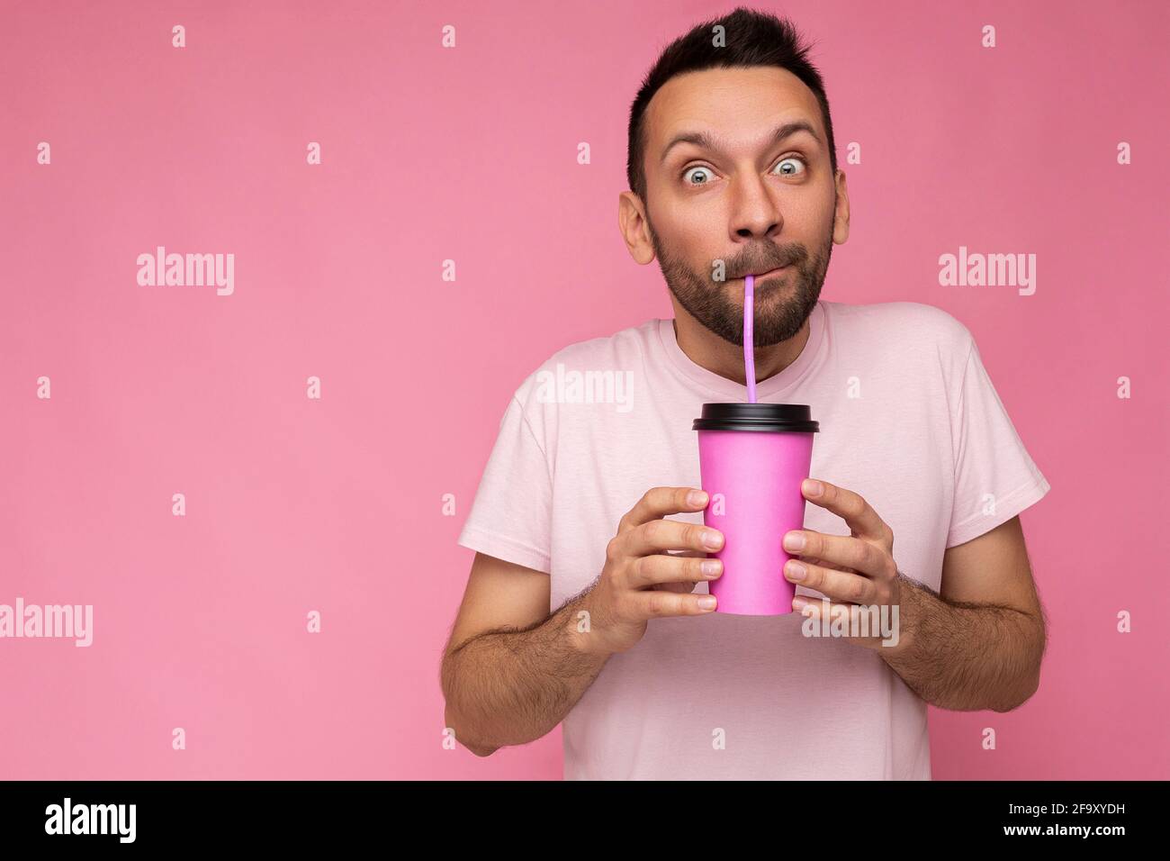 https://c8.alamy.com/comp/2F9XYDH/amazed-handsome-funny-joyful-young-brunette-unshaven-male-person-with-beard-wearing-white-t-shirt-isolated-over-pink-backgroung-wall-holding-paper-cup-2F9XYDH.jpg