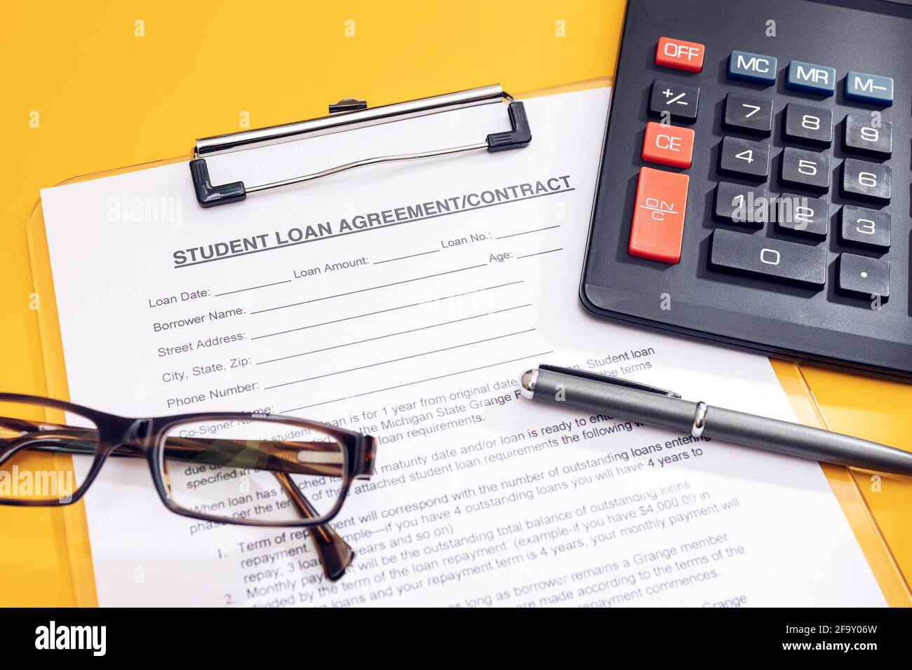 Blank Student Loan Application, calculator, pen and eyeglasses on table