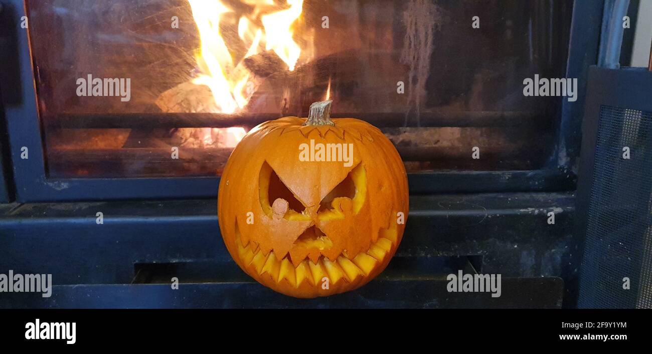 pumpkin carved for halloween with the background fireplace flames Stock Photo