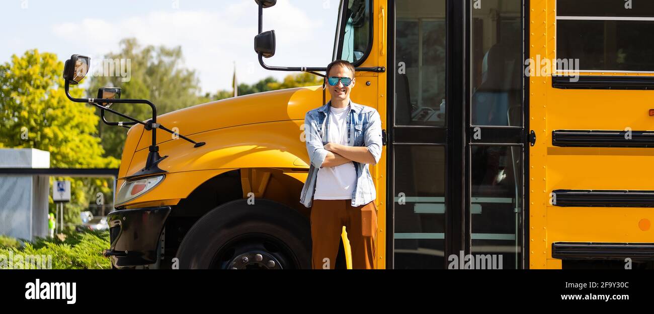 Portrait of smiling teacher near school bus Stock Photo - Alamy