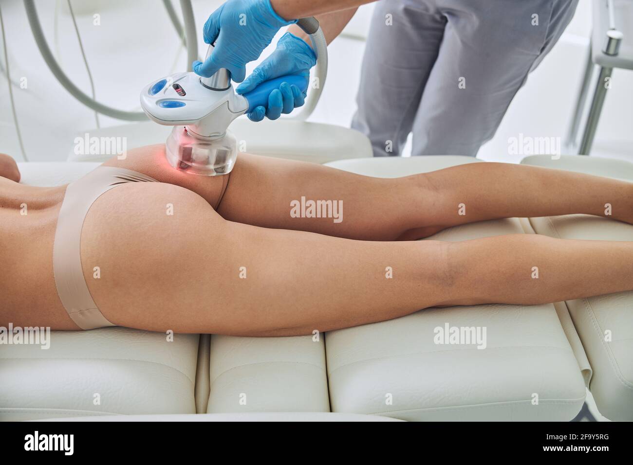 Focused image of beautician doing Rf skin tightening in body client in beauty center Stock Photo