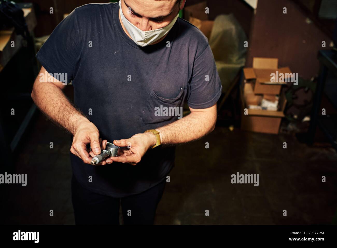 Closeup shot of a Hispanic mechanical engineer controlling the lathe machine in a factory Stock Photo