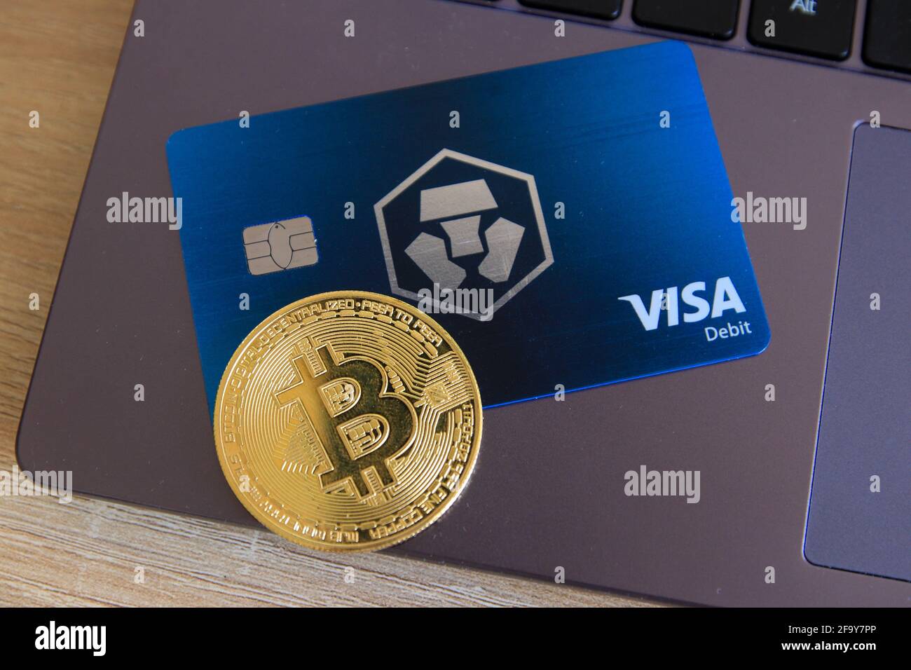 Berlin, Germany - April 21, 2021: Crypto.com Midnight Blue Visa card and a bitcoin currency lying on laptop. Crypto.com is a beginner-friendly crypto Stock Photo