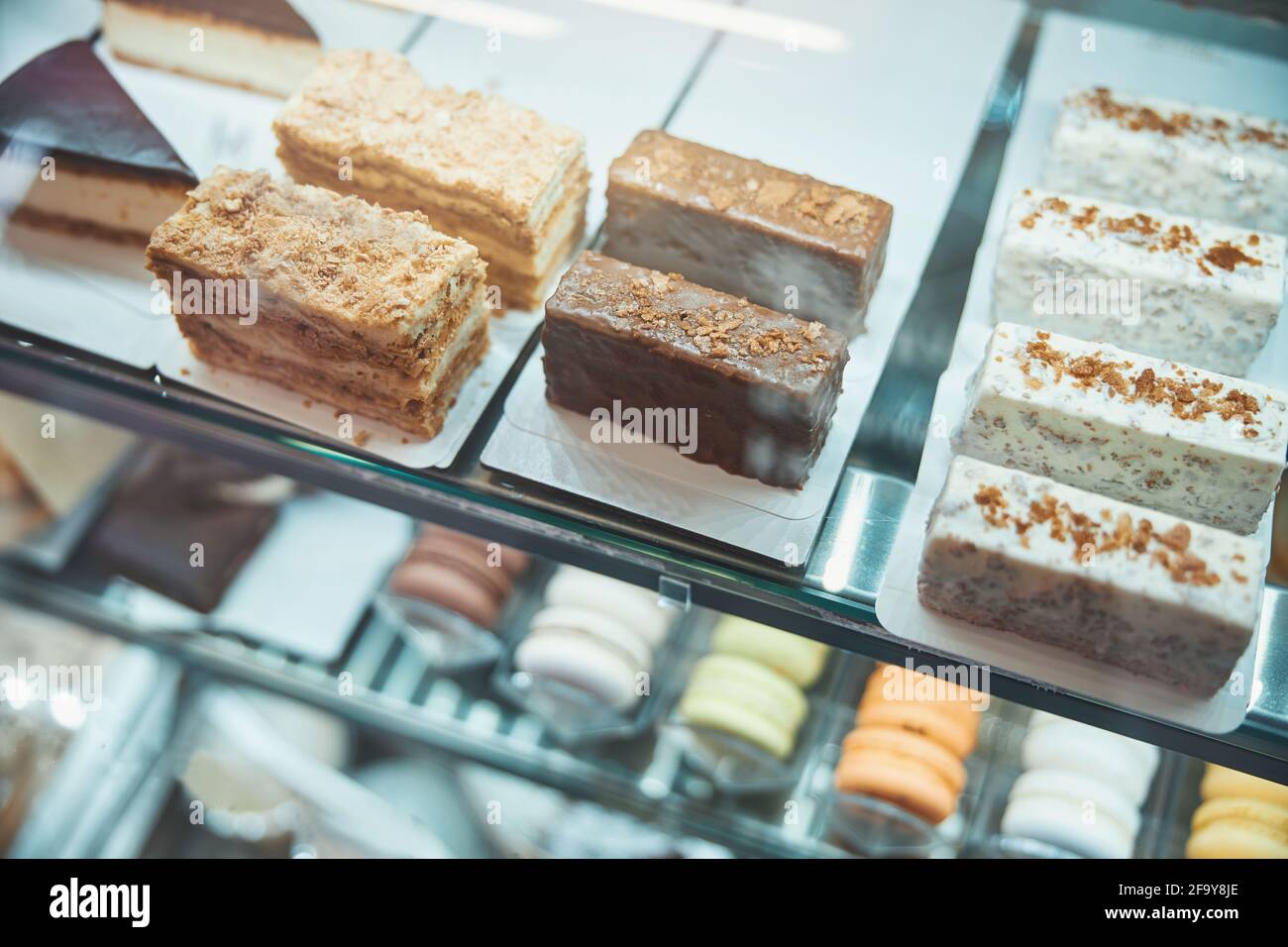 Pieces of various desserts lined up under the glass Stock Photo