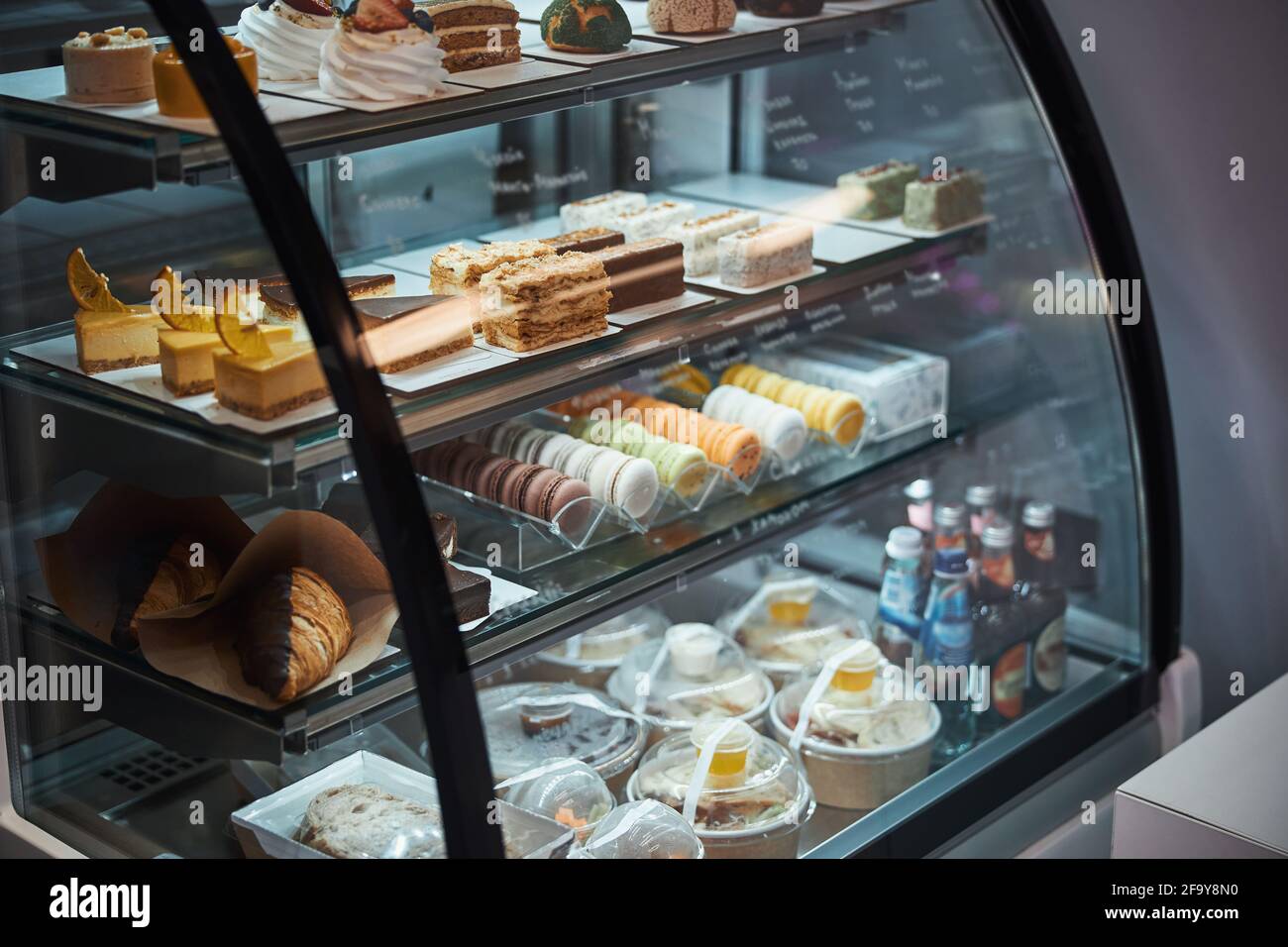 Diverse choice of miscallaneous desserts presented in cafe fridge Stock Photo