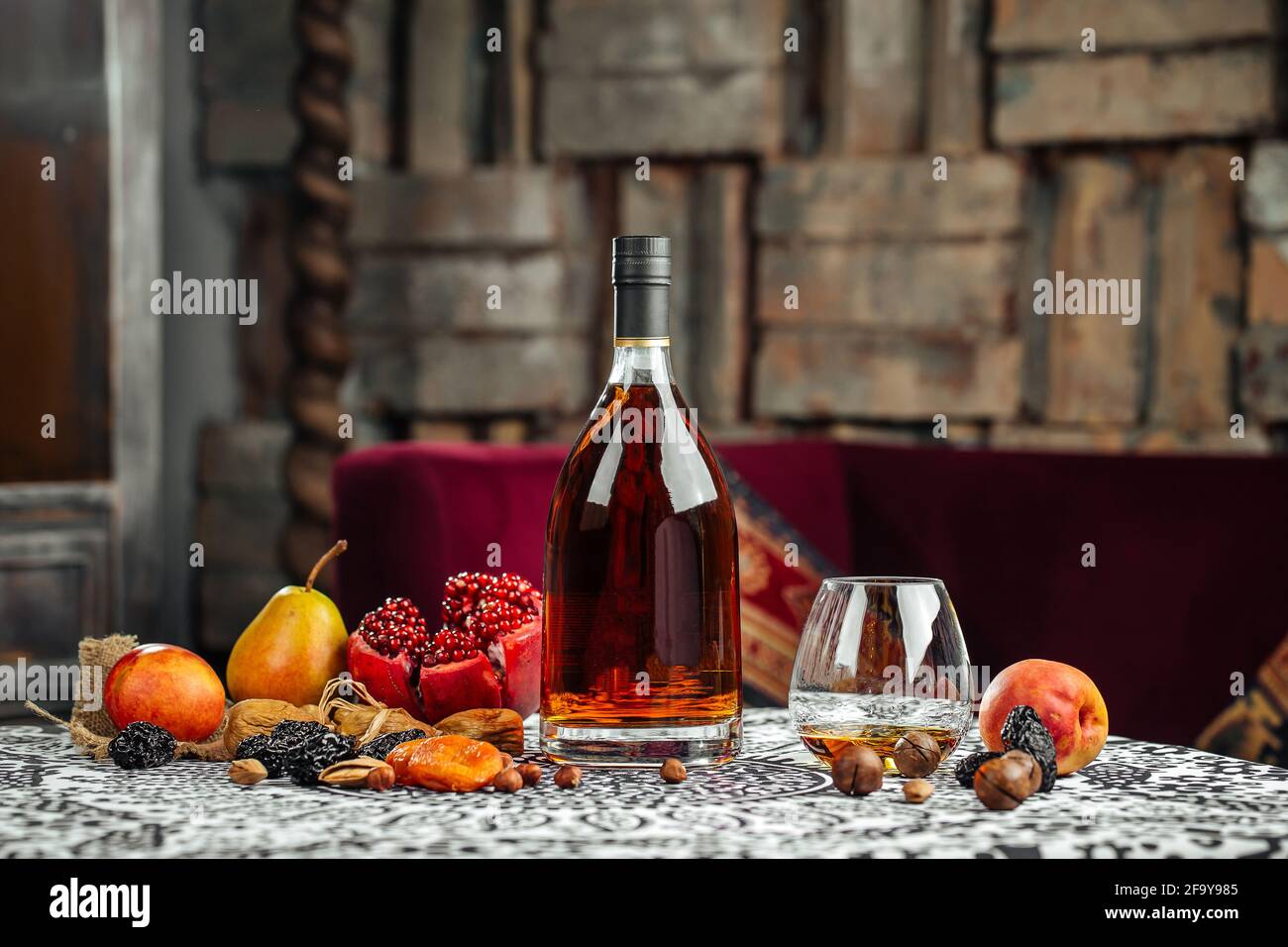 Elegant bottle of cognac with fruits Stock Photo