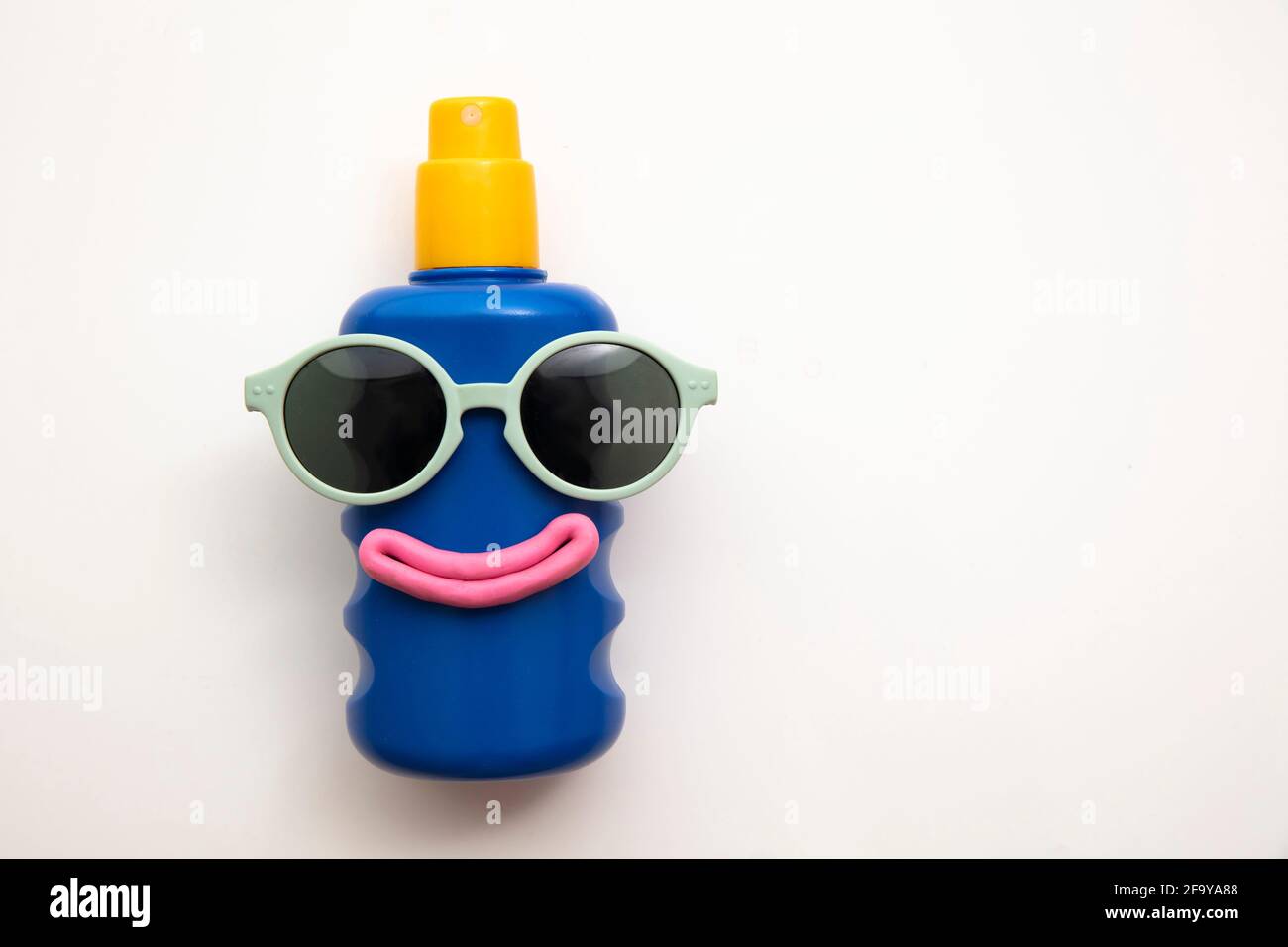 Suncream lotion bottle with a happy face and sunglasses Stock Photo