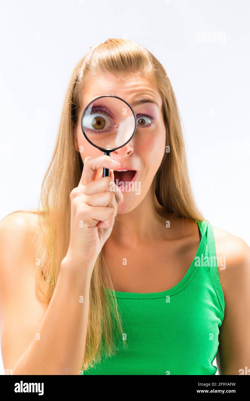Woman looking through magnifying glass or loupe Stock Photo - Alamy