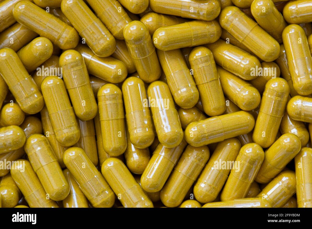 Turmeric Curcumin supplement capsules scattered loosely, close up macro flat lay image. Sold as an herbal anti-inflammatory remedy. Stock Photo
