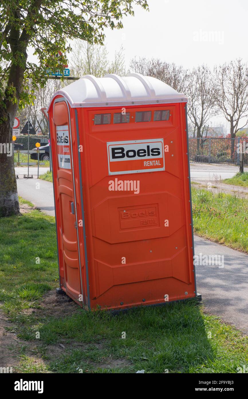 Sint Gillis Waas, Belgium, April 21, 2021, A rented mobile orange toilet for workers at a construction site Stock Photo