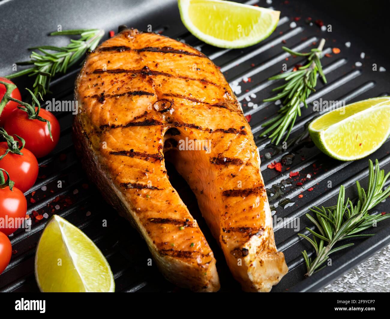 grilled steak fish salmon, trout in a grill pan, spicy, tomato, close up, top Stock Photo