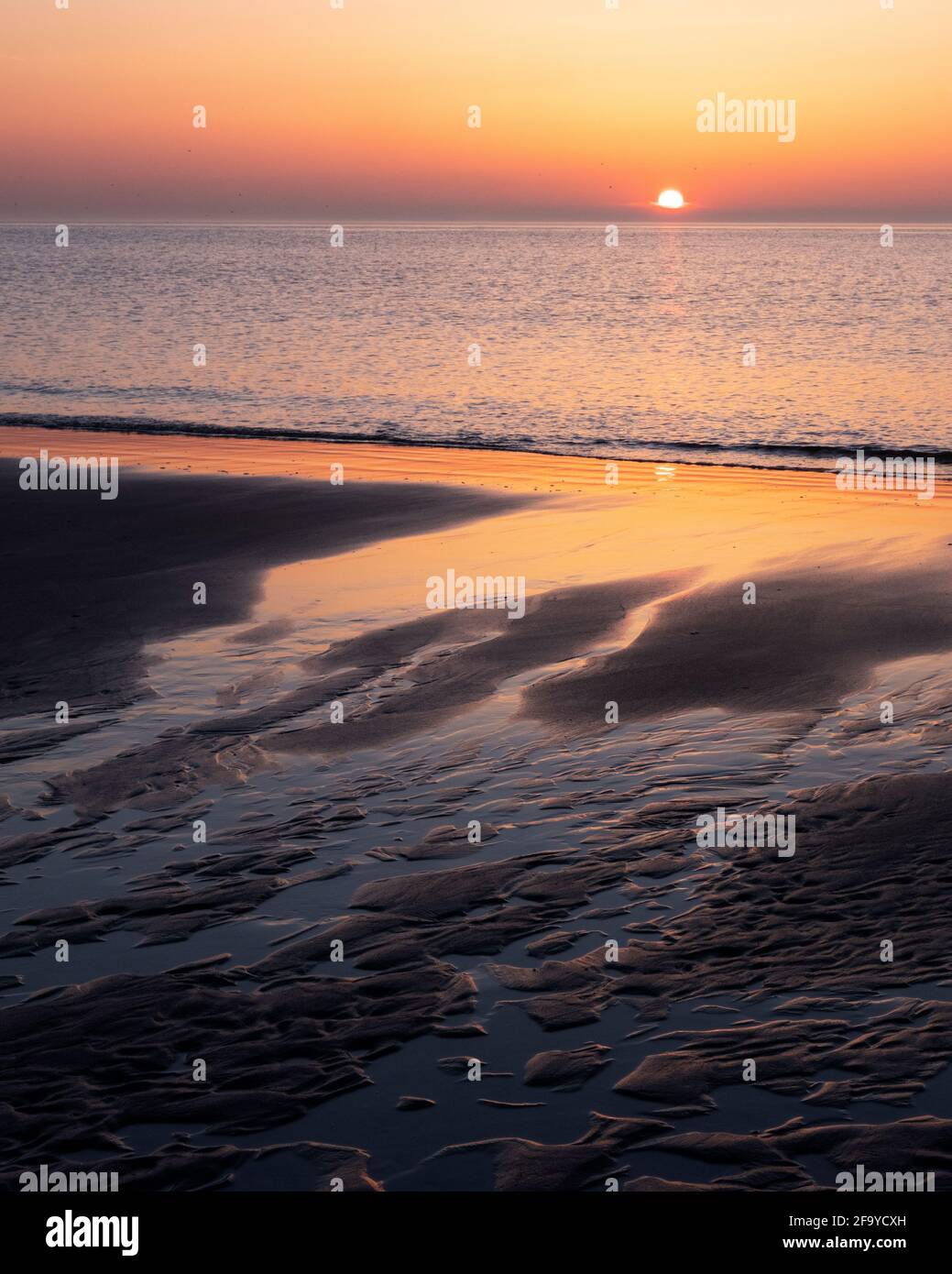 Setting Sun Reflection pattern in sand and colorful reflection of setting sun in water Stock ...