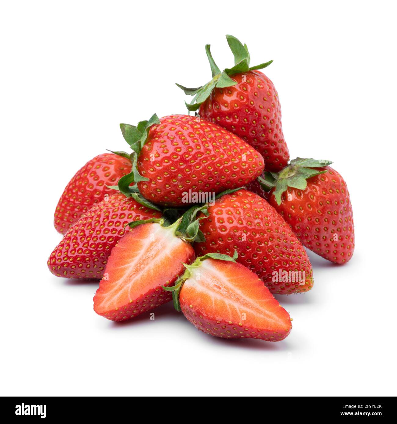 Heap of fresh picked whole and half ripe red strawberries isolated on white background Stock Photo