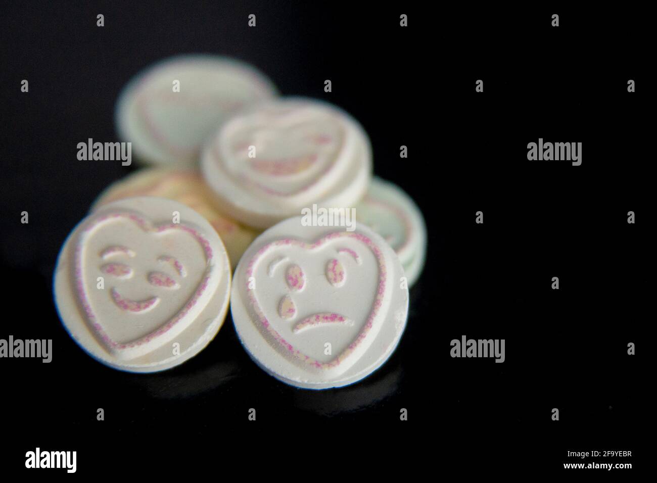 Love heart sweet emojis emoticons on black background, sad face and happy face. Focus on sad face. Mental health, depression, mental health awareness Stock Photo