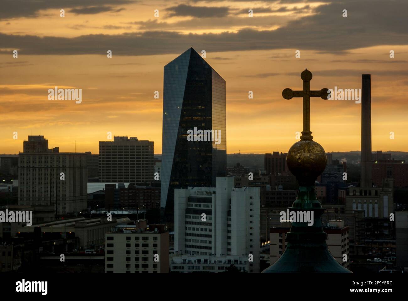 A high view of the cross of the Cathedral Basilica of Saints Peter and Paul, with the Cira Center beyond, at sunset in Philadelphia, USA. Stock Photo