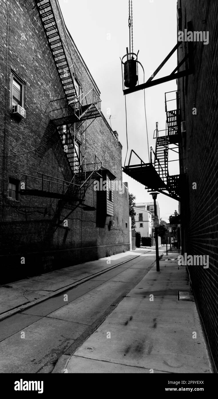 Fire escapes on brick buildings in a back street in Philadelphia, USA. B&W. Stock Photo