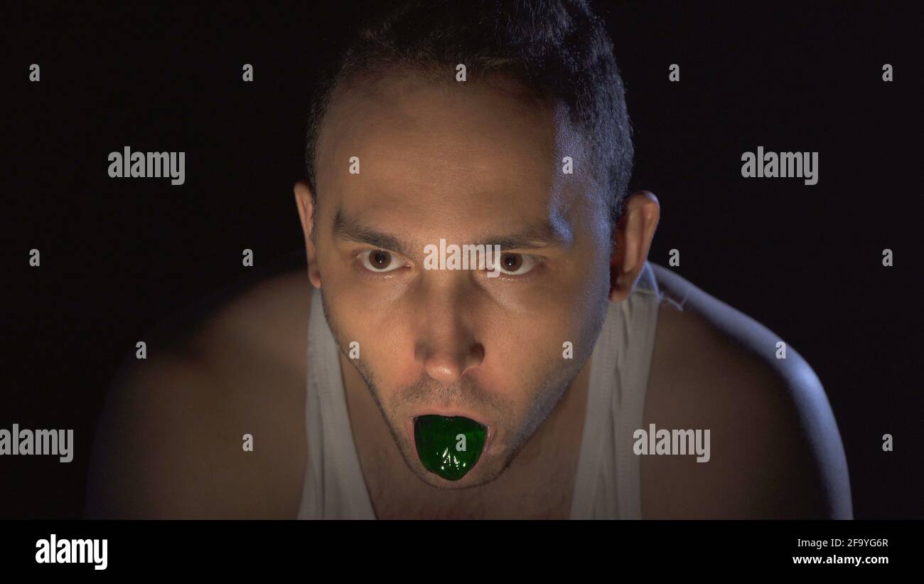 Photo of madman with green mucus in mouth Stock Photo