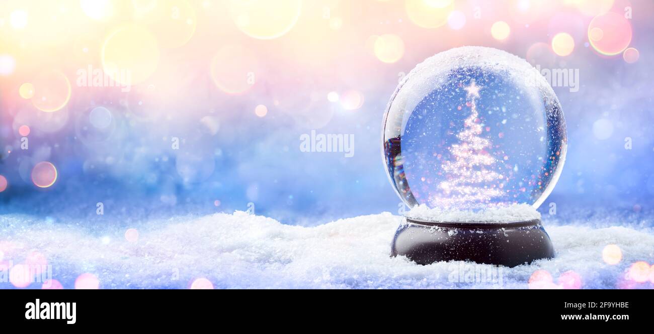 Shiny Christmas Tree In Snow Globe On Snow With Golden Lights Stock ...