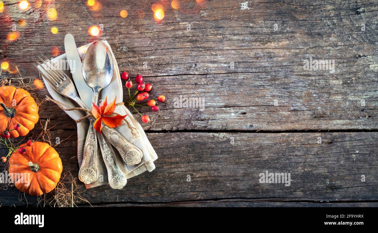 Thanksgiving Place Setting - Rustic Table With Silverware And Pumpkins Stock Photo