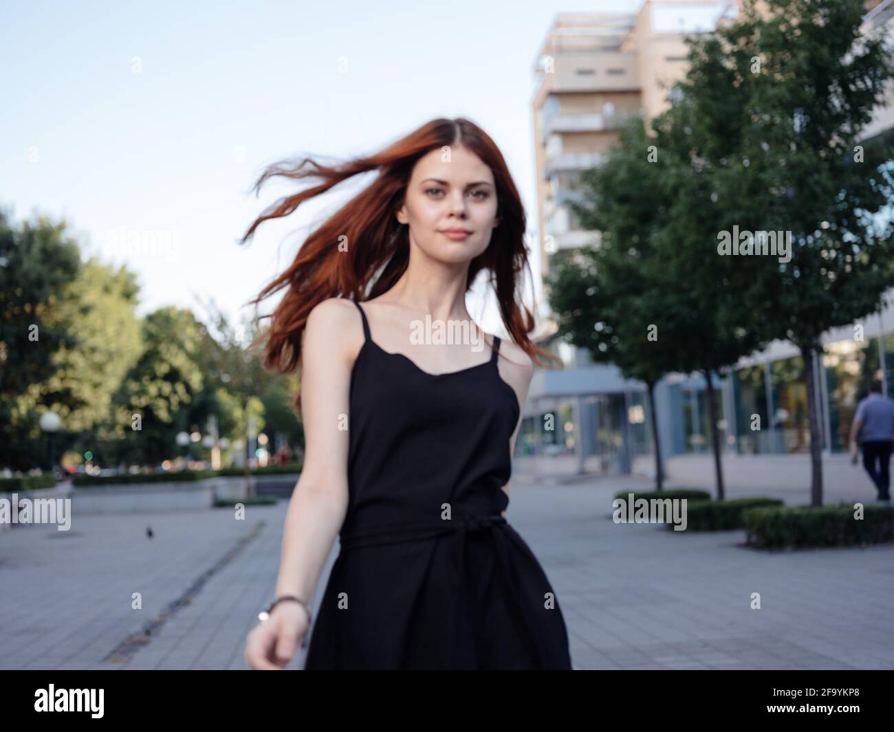 Beautiful woman in black dress walks back hi-res stock photography and ...