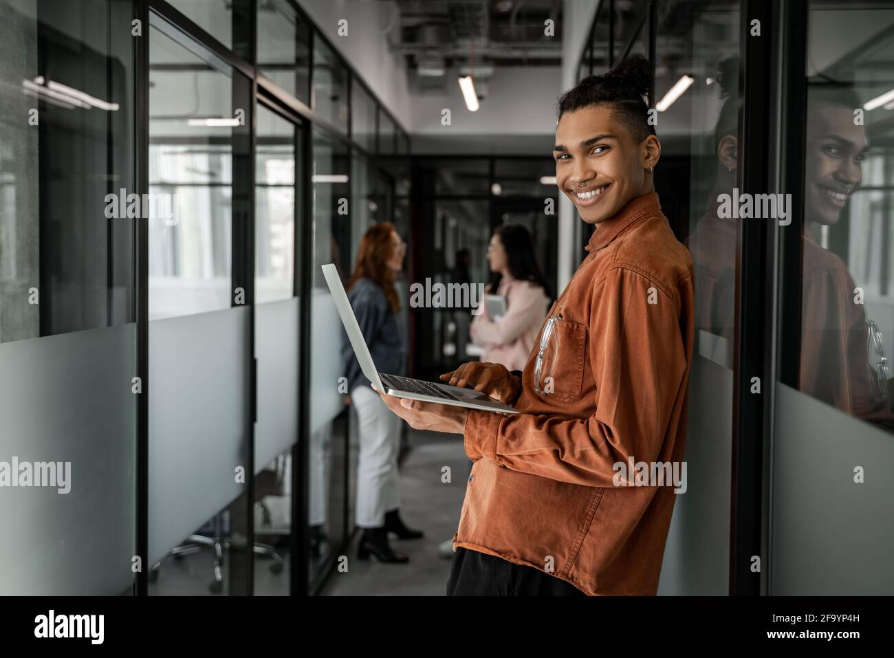 happy african american student using laptop near classmates on blurred ...
