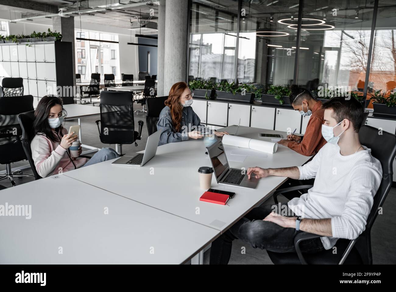 interracial students using gadgets while sitting at desk Stock Photo