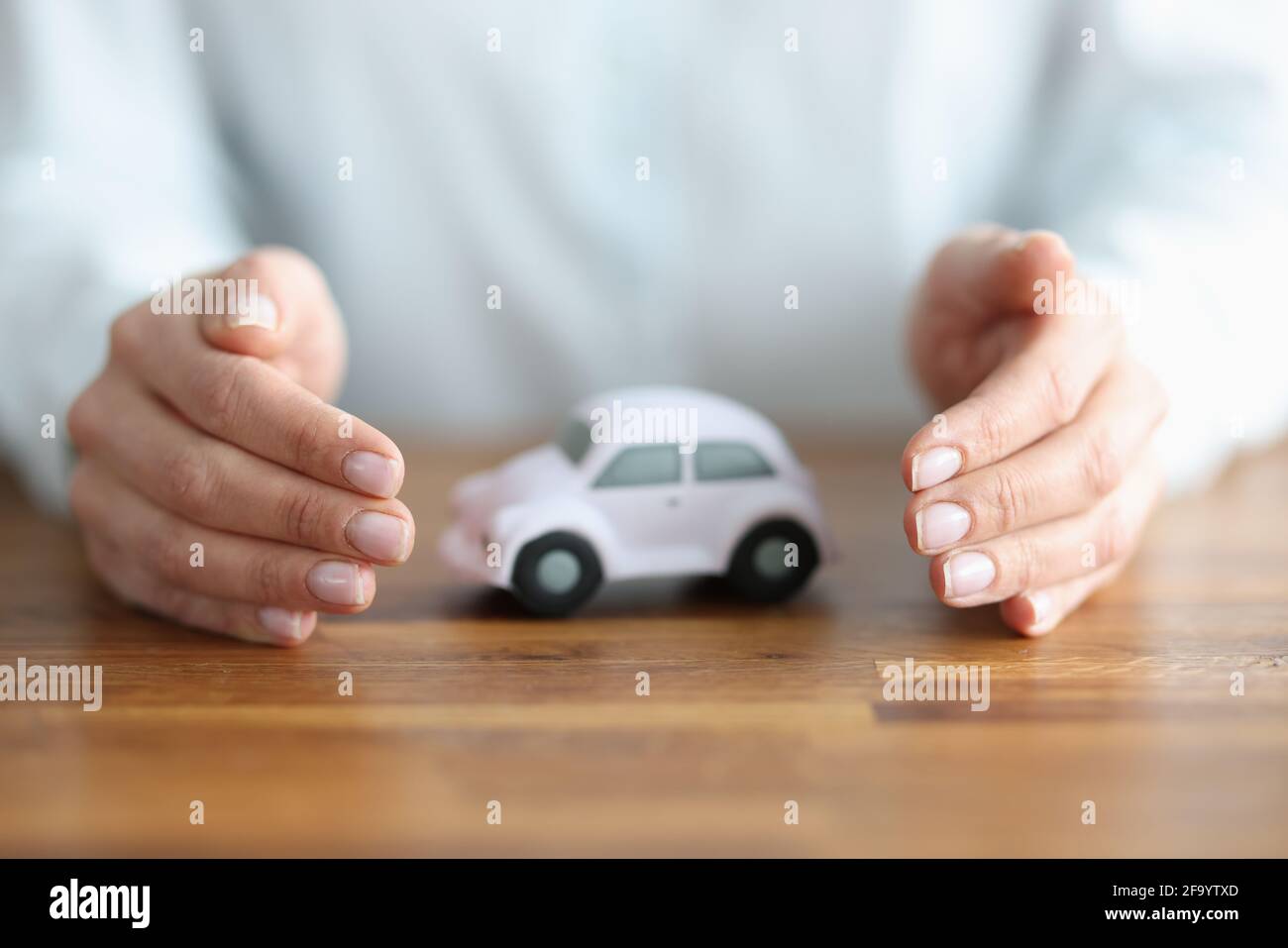 There is white car inside woman hands Stock Photo