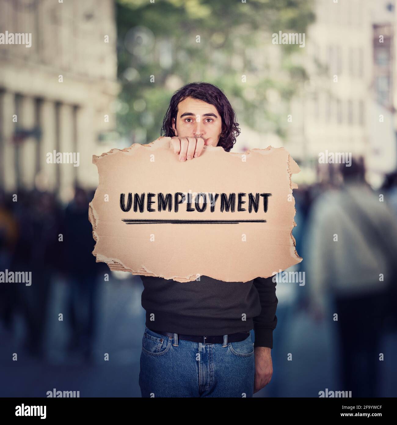 Unemployment as global issue. Unemployed man activist holding a cardboard banner, participating in a street demonstration protest. Social problem, lac Stock Photo