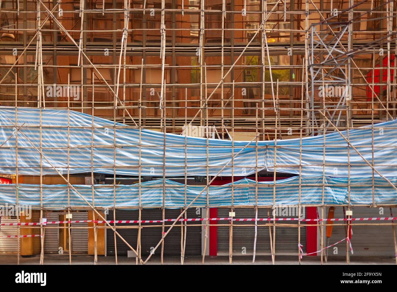 Buiding wrapped in traditional Chinese scaffolding made of bamboo in Hong Kong. Stock Photo