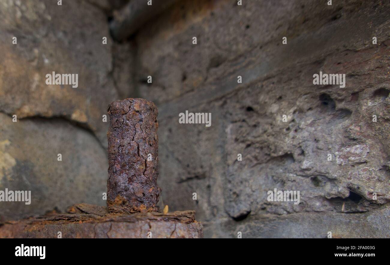 Rusty metal peg against dark grey brick background with copyspace. High quality photo Stock Photo