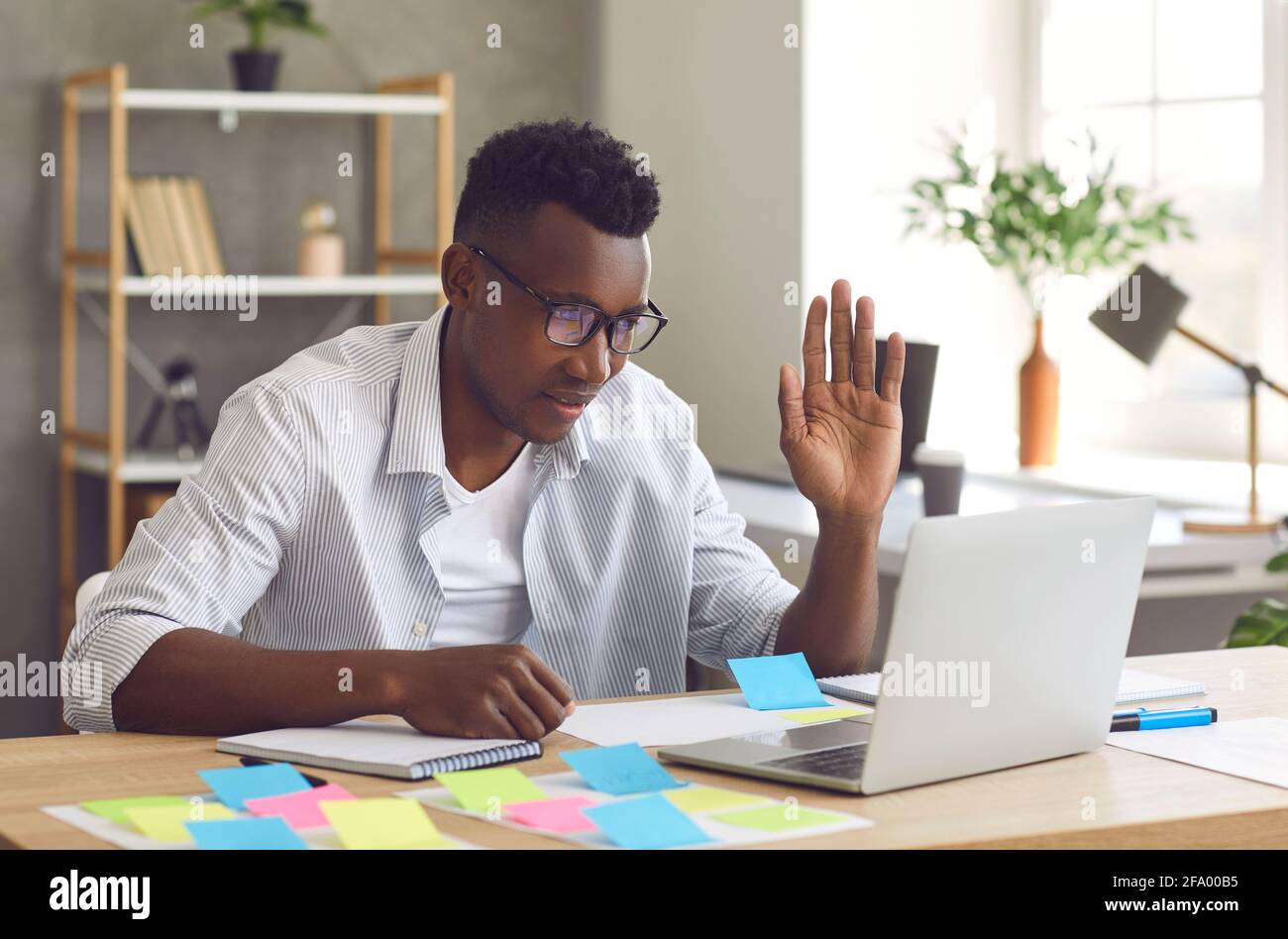 Portrait cheerful black man has video call on laptop computer from home