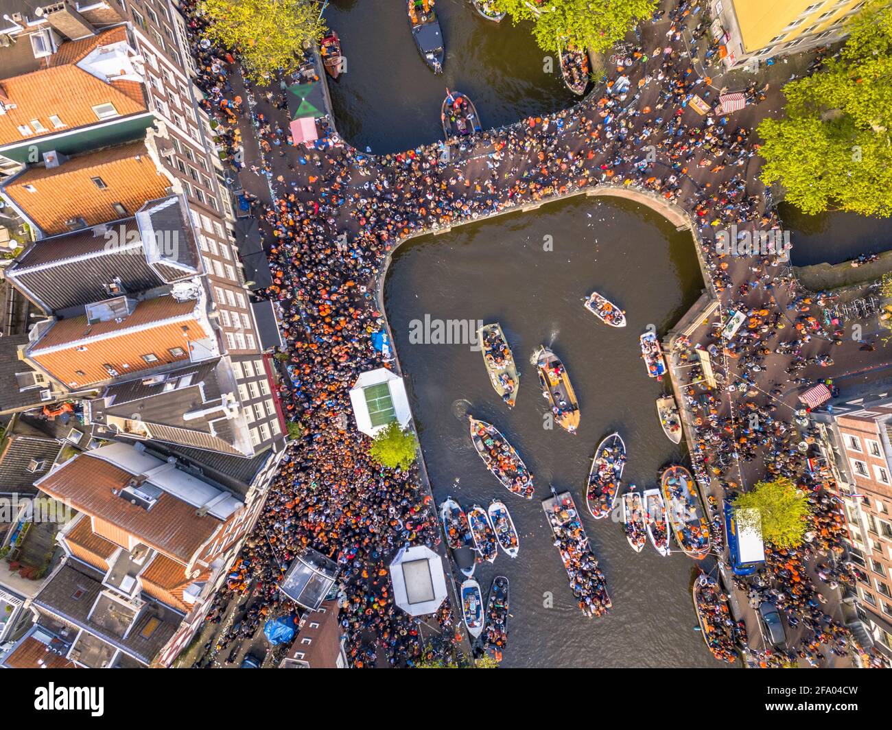 Canal boat parade on Koningsdag Kings day festivities in Amsterdam. Birthday of the king. Seen from helicopter. Stock Photo