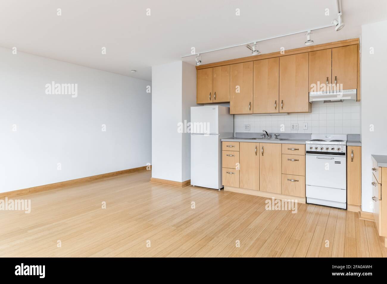 A maple kitchen in an empty city apartment with white appliances ...
