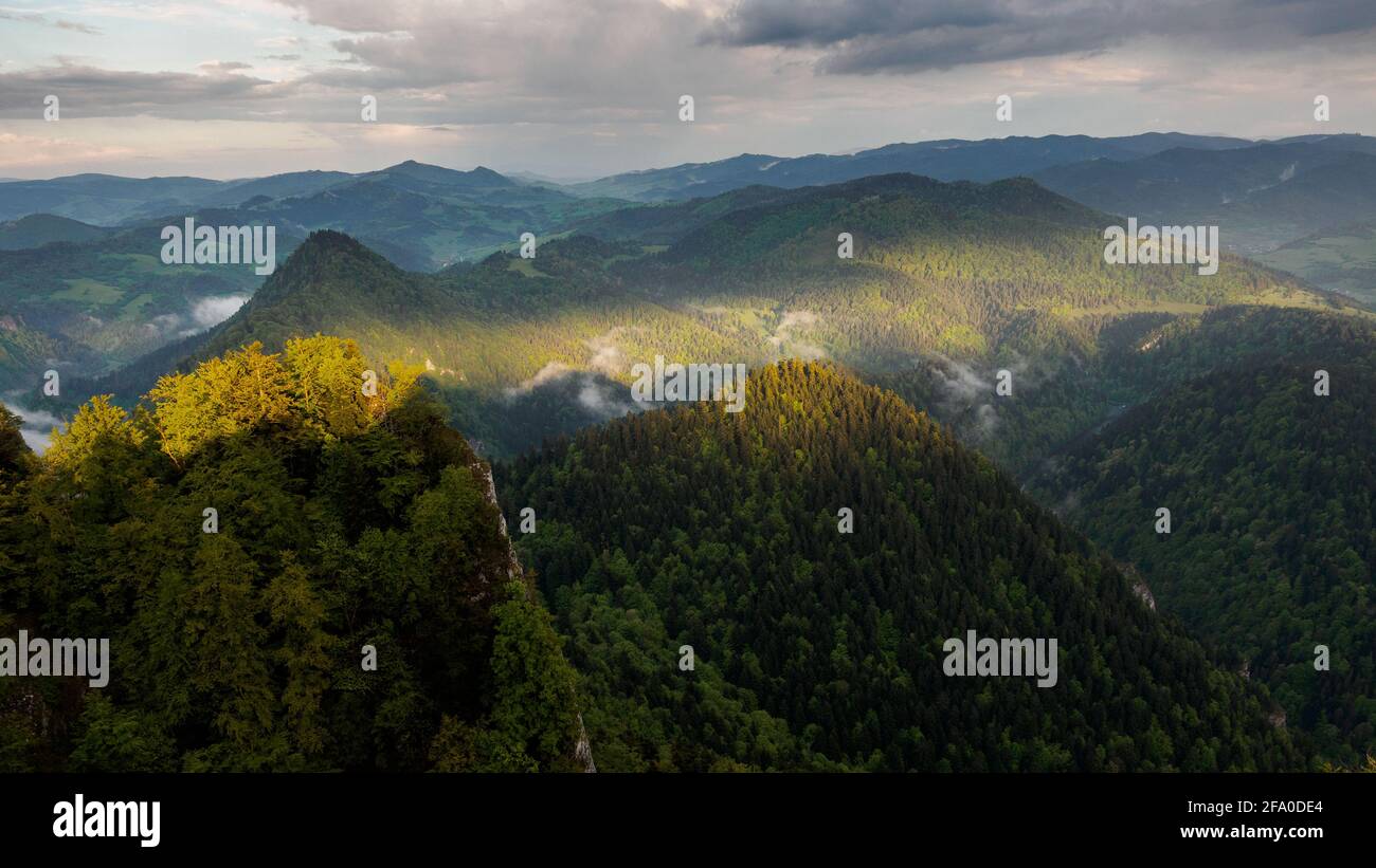 View from the top of Trzy Korony towards the east of the Little Pieniny Mountains on spring.The ray of the setting sun breaks through the clouds Stock Photo
