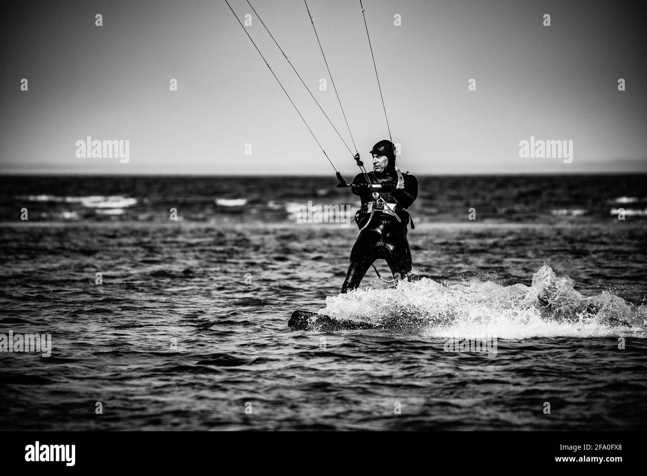 professional kiter makes the difficult trick on a beautiful background of spray and beautiful mountains of Mauritius Stock Photo