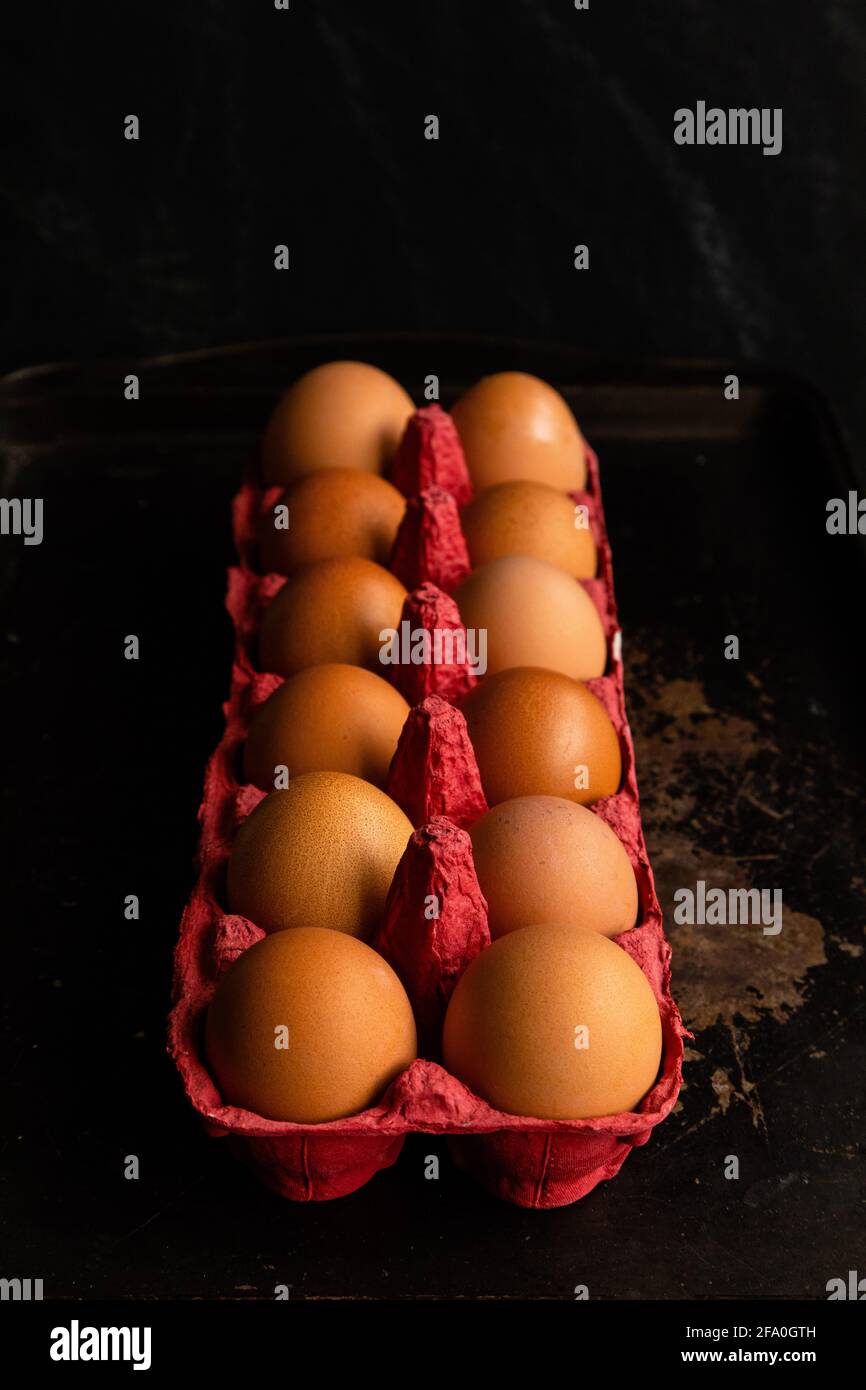 One dozen eggs, in a red egg carton Stock Photo