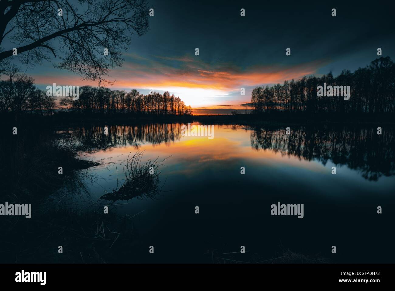 Reflections off a vivid Sunset sky over a Lake Stock Photo - Alamy