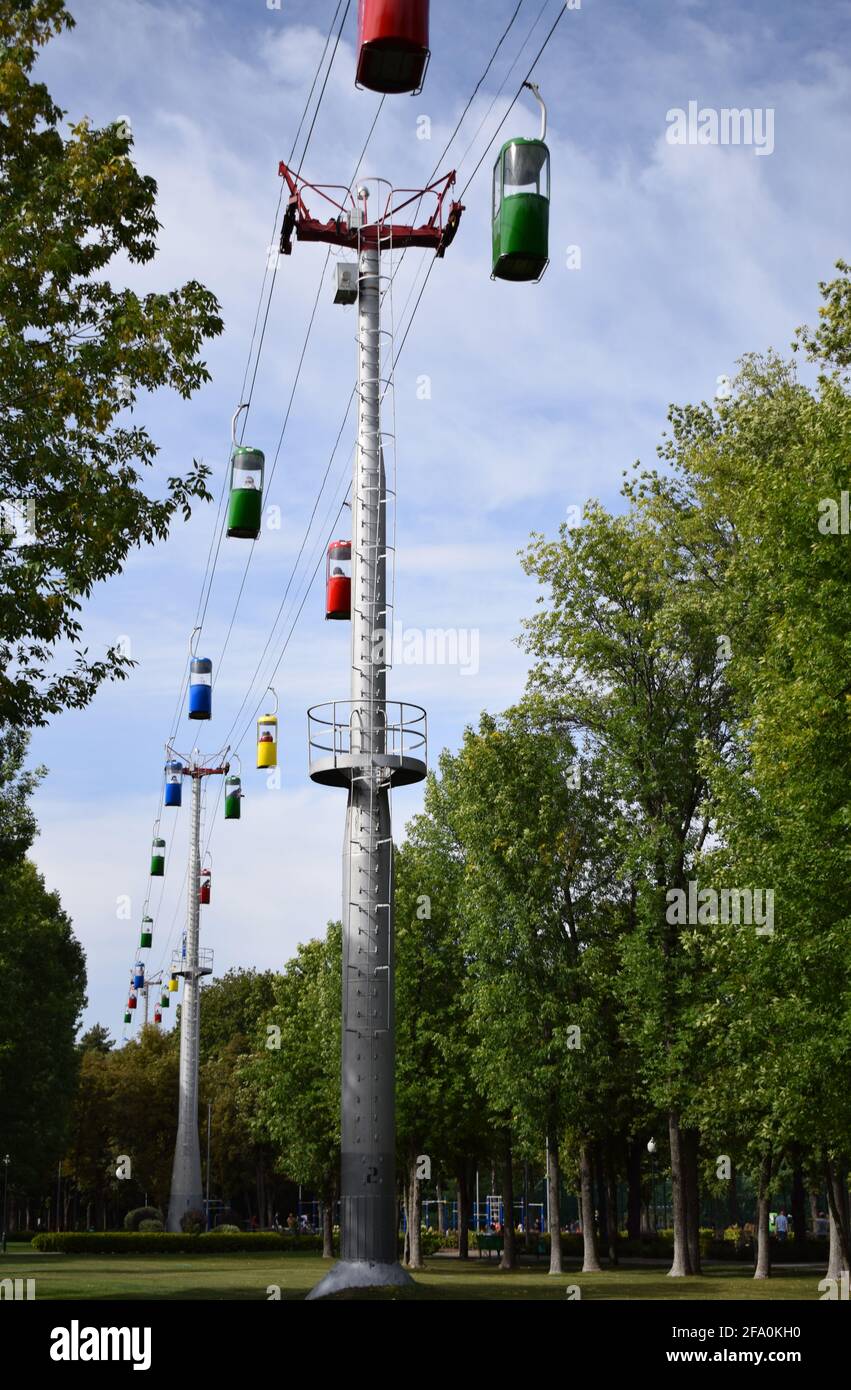 Brightly colored cable cars carry tourists. Running on wires supported ...