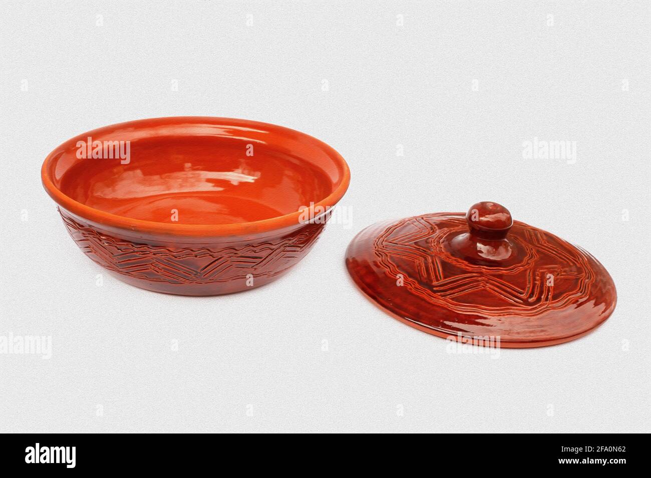 Annealed clay pot with a cover for cooking and prolonged storage of hot dishes on light gray structured background, stylish artwork Stock Photo