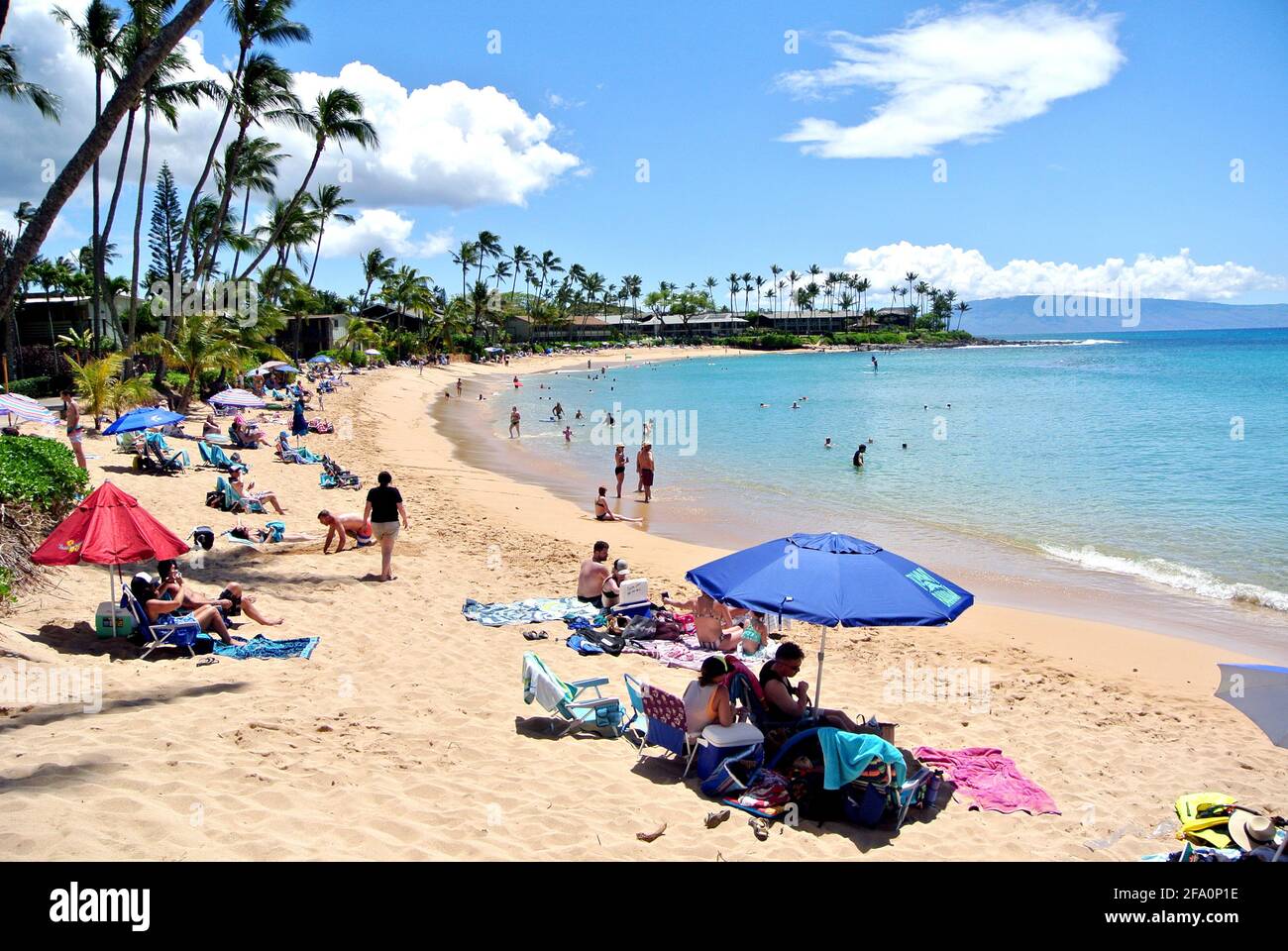 tourists relax under umbrellas and swim and play on the sandy sunny kaanapali beach west of the town of Lahaina on the island of Maui Hawaii usa Stock Photo