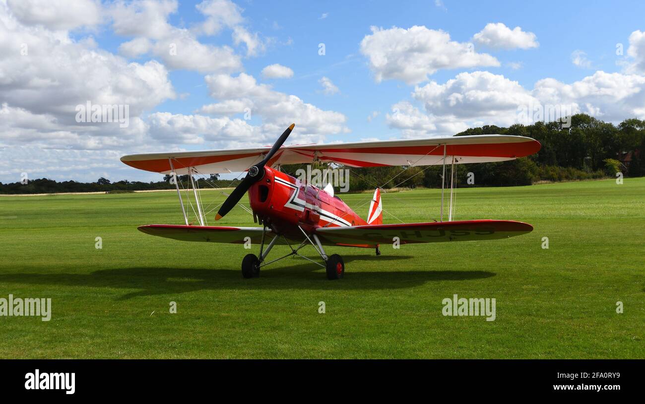 ICKWELL, BEDFORDSHIRE, ENGLAND - SEPTEMBER 06, 2020: Vintage Stampe  SV.4C, G-HJSS  1101  Biplane  on airstrip grass with blue sky and clouds. Stock Photo