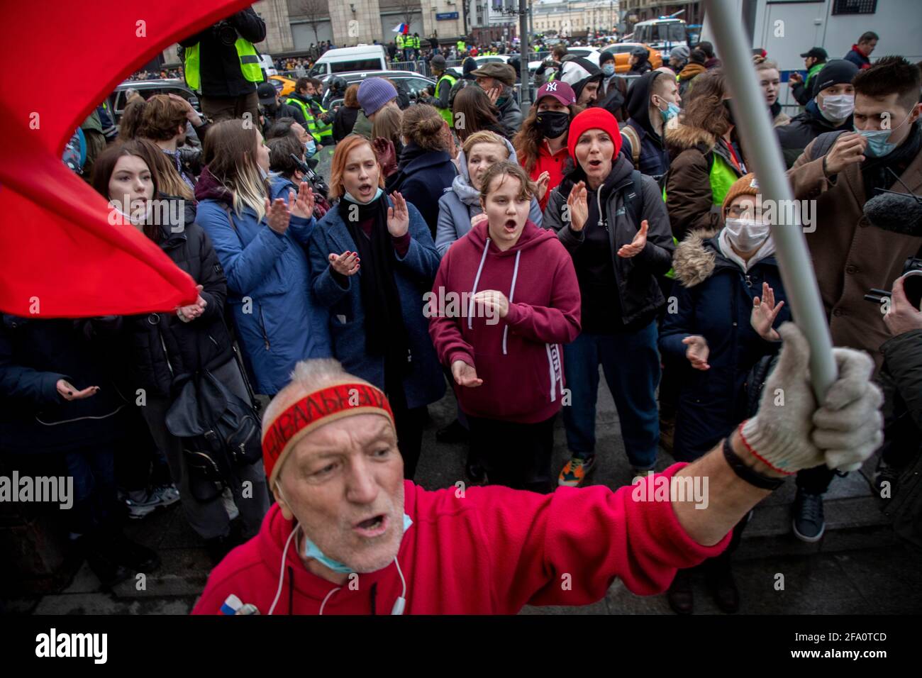 Moscow, Russia. 21st of April, 2021 An opposition supporter waves a Russian national flag as he walks in a street during a rally in support of jailed Kremlin critic Alexei Navalny, in central Moscow, Russia. Jailed Kremlin critic Alexei Navalny's team called for demonstrations in more than 100 cities, after the opposition figure's doctors said his health was failing following three weeks on hunger strike. Stock Photo