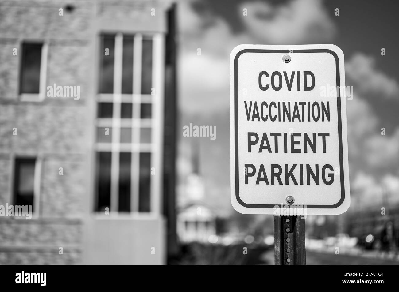 COVID vaccination sign in front of hospital with empty spaces Stock Photo