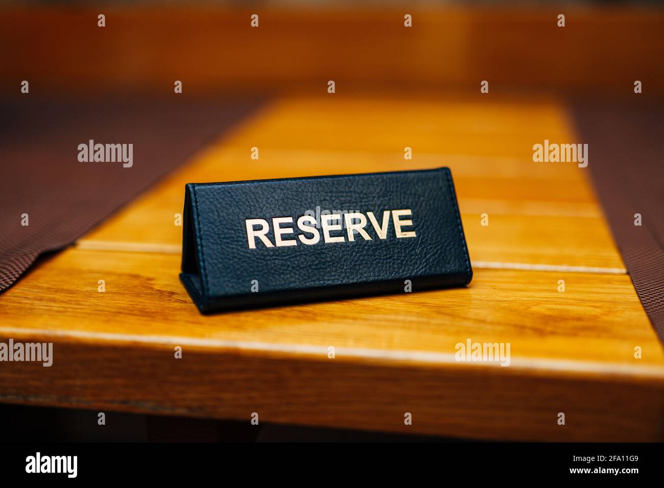 Sign reserve on a wooden table in a restaurant. Title: Reserve Stock Photo