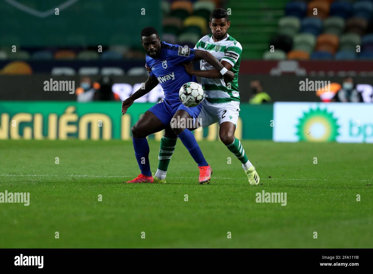 Lisbon, Portugal. 21st Apr, 2021. Matheus Reis of Sporting CP (R ) vies with Silvestre Varela of Belenenses SAD during the Portuguese League football match between Sporting CP and Belenenses SAD at Jose Alvalade stadium in Lisbon, Portugal on April 21, 2021. Credit: Pedro Fiuza/ZUMA Wire/Alamy Live News Stock Photo